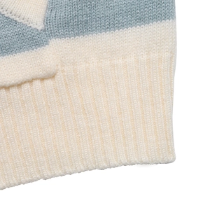 Gros plan détaillé de l'ourlet en maille côtelée rayée bleue et blanche d'un pull doux