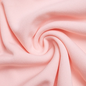 Gros plan sur la texture du tissu en maille rose ajourée au design élégant
