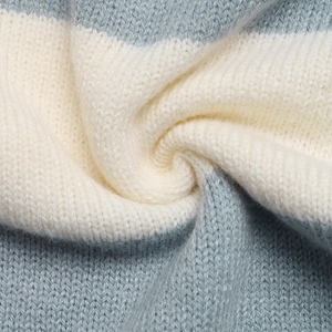 Gros plan sur la texture tricotée à rayures bleu et beige d'un pull à capuche