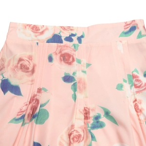 Détails de l'imprimé floral rose vintage et des plis verticaux sur jupe d'été rose