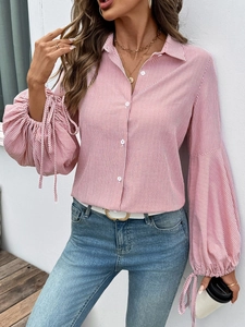 Détail du chemisier rayé rose et blanc avec manches bouffantes et liens décoratifs