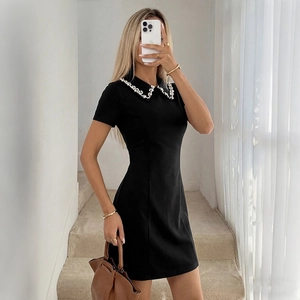 Elegant black slim-fit mini dress with white pearl beaded collar and short sleeves