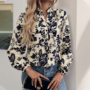 Detail of floral printed blouse with elegant vertical pleats and a stylish stand collar
