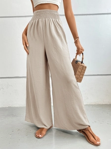 Detail of high waist shirred elastic waistband on beige wide leg flowy trousers