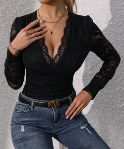 Détail du body en dentelle noire avec décolleté plongeant en V et bordure ciliée