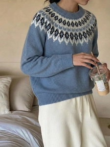 Detailed close-up of light blue Fair Isle knit sweater with grey geometric neck pattern