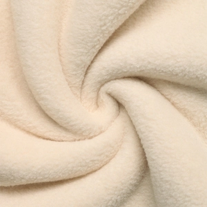 Close-up of soft cream fleece fabric showing the warm texture and plush fiber details