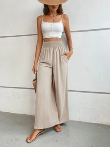 Detail of high-waist wide-leg trousers with elastic waistband and lightweight fabric
