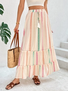 Detail eines Boho-Maxirocks mit bunten Wellenmustern und Kordelzug mit Quasten am Bund