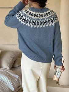 Detail of blue knitted sweater featuring ethnic jacquard pattern and drop shoulder design