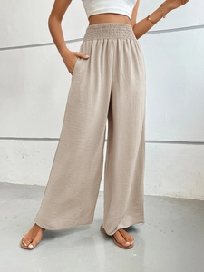 Detail of high waisted wide leg trousers with elastic waist and micro-wrinkle texture