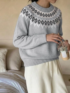 Close-up of grey knit sweater with Fair Isle geometric patterns around the neckline