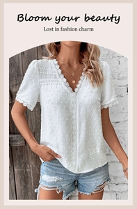 Close-up of white Swiss dot textured blouse with delicate lace trims and V-neckline detail