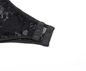 Détail d'un body en dentelle noire avec fermeture à boutons-pression réglables à l'entrejambe