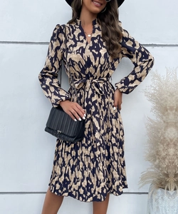Détail d'une robe midi avec col en V, ourlet plissé et texture à imprimé abstrait