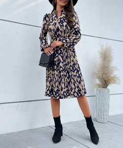 Détail d'une robe midi à imprimé abstrait avec ceinture élégante et texture plissée