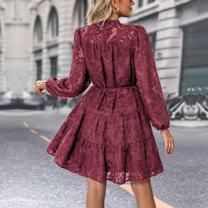 Detail of burgundy dress with 3D floral texture and layered tiered skirt back view