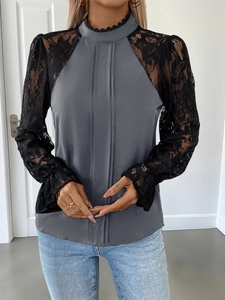Detail of high collar lace trim and vertical pleats on a long sleeve grey blouse