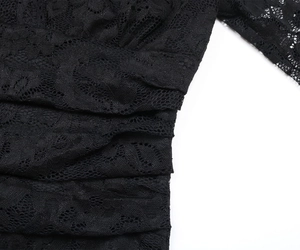 Détail de dentelle noire transparente avec broderie florale et texture froncée