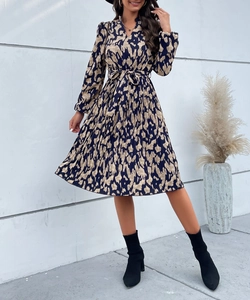Détail de l'ourlet plissé et de la ceinture sur cette robe mi-longue à fleurs et manches longues