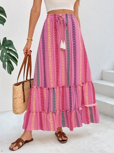 Detail eines Boho-Maxirocks mit pinkem Geometrie-Muster und weißen Quasten-Kordelzügen