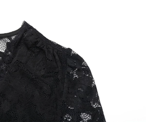 Gros plan d'un body en dentelle noire avec broderies florales délicates et tissu résille