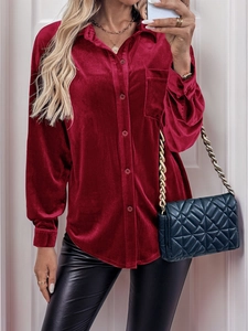Detailed texture of dark red velvet shirt featuring button-down front and chest pocket