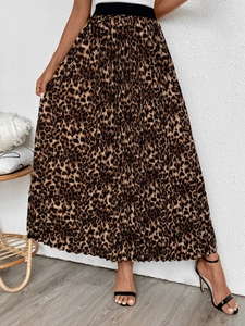 Detail of high-waist leopard print pleated skirt with a slim black elastic waistband