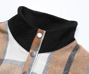 Detail of the high collar with metal snap buttons and plaid pattern on the sleeve