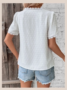 Detailed back view of a white Swiss Dot top with floral lace trim and V-neckline