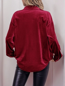 Rear view of a burgundy velvet long sleeve shirt with a curved hem and drop shoulders