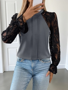 Detailed view of grey long-sleeved shirt with black lace sleeves and pleated front design