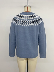 Detail view of ethnic jacquard pattern and rib-knit cuffs on blue crewneck sweater