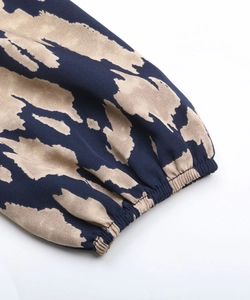 Détail des poignets plissés élastiques sur robe à manches longues au motif bleu et kaki