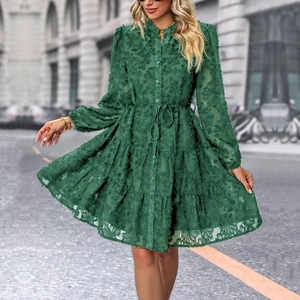 Detail of forest green dress featuring floral texture and tiered ruffled skirt