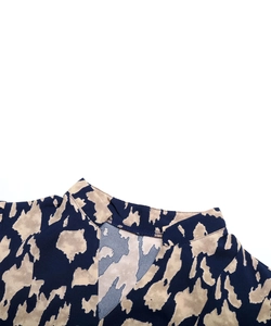 Détail du col en V et de l'imprimé léopard abstrait sur une robe bleu marine