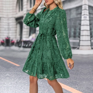 Detail of dark green dress showing layered tier skirt and flocked textured fabric