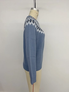 Detail showing Nordic geometric jacquard pattern and ribbed cuffs on blue knit sweater