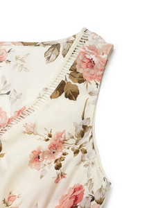 Détail de robe à fleurs avec dentelle ajourée blanche sur un tissu beige délicat
