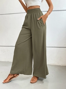Detailed macro shot of olive green wide-leg pants with elastic pleated high waist texture