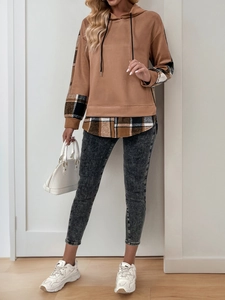 Vue complète d'un sweat à capuche marron avec manches à carreaux et jean skinny gris