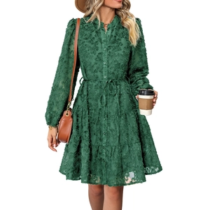 Detail of dark green long-sleeve dress with textured floral fabric and tiered cake skirt