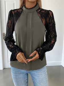 Detail of olive green mock neck blouse featuring black lace sleeves and pleated front
