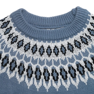 Close-up of Fair Isle jacquard pattern on a gray-blue knit sweater with ribbed neckline