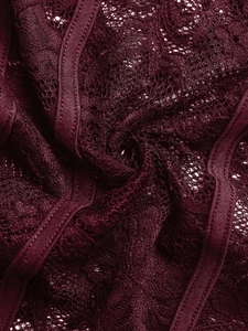 Vue macro du tissu en dentelle florale bordeaux foncé et des bretelles élastiques