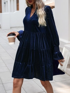 Detail of tiered dark blue velvet dress with elegant ruffled cuffs and V-neckline texture