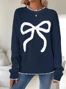 Dettaglio maglione blu navy a maglia con fiocco bianco e cuciture a contrasto
