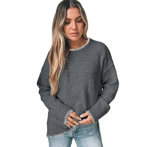 Detail of dark grey pullover sweater with decorative white hand-stitched seams and side slits
