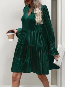 Detail of V-neck long sleeve dark green velvet tiered dress with ruffled cuffs