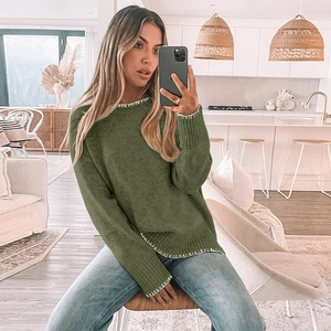 Detailed view of olive green round neck sweater with white contrast decorative stitching